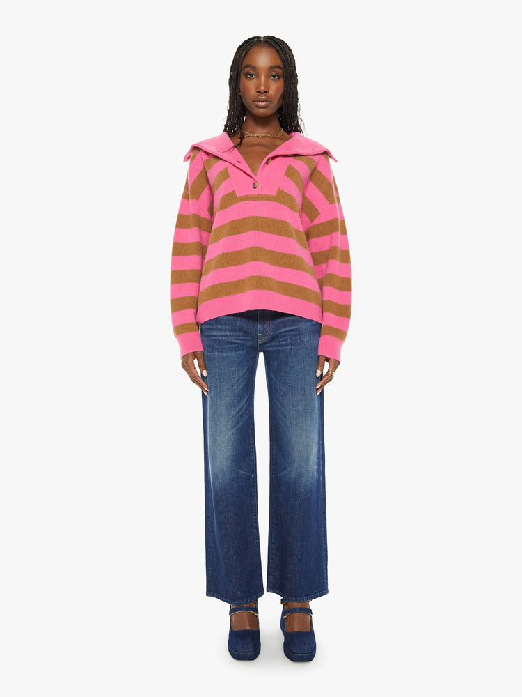 Full body view of a woman oversized collar, buttoned V-neck, long balloon sleeves and a loose fit sweater in a hot pink and brown stripe pattern.