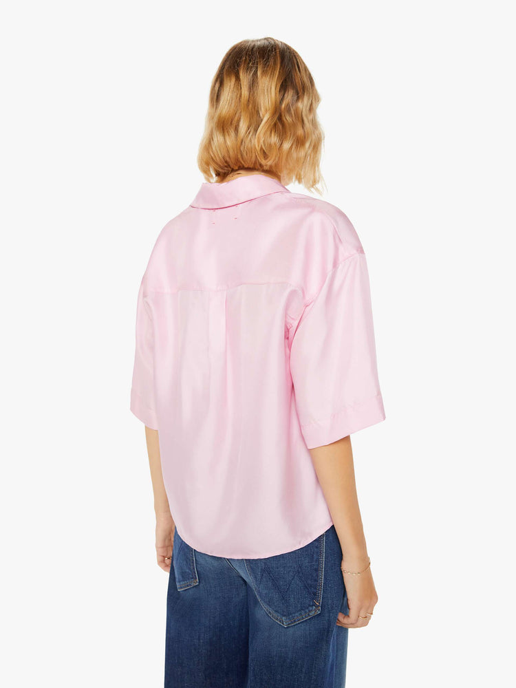 Back view of a woman pink short sleeve button-down with a collared neck, drop shoulders, oversized short sleeves and a boxy fit.