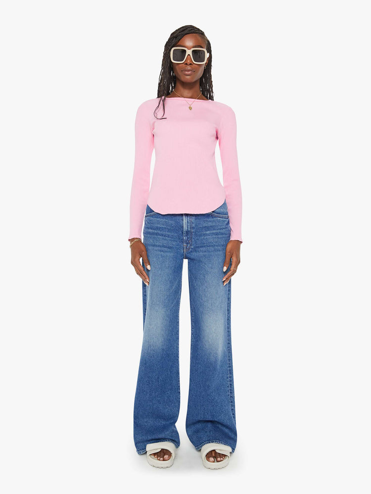 Full body view of a woman baby pink long-sleeve tee features a crewneck and curved hem with a slim fit.