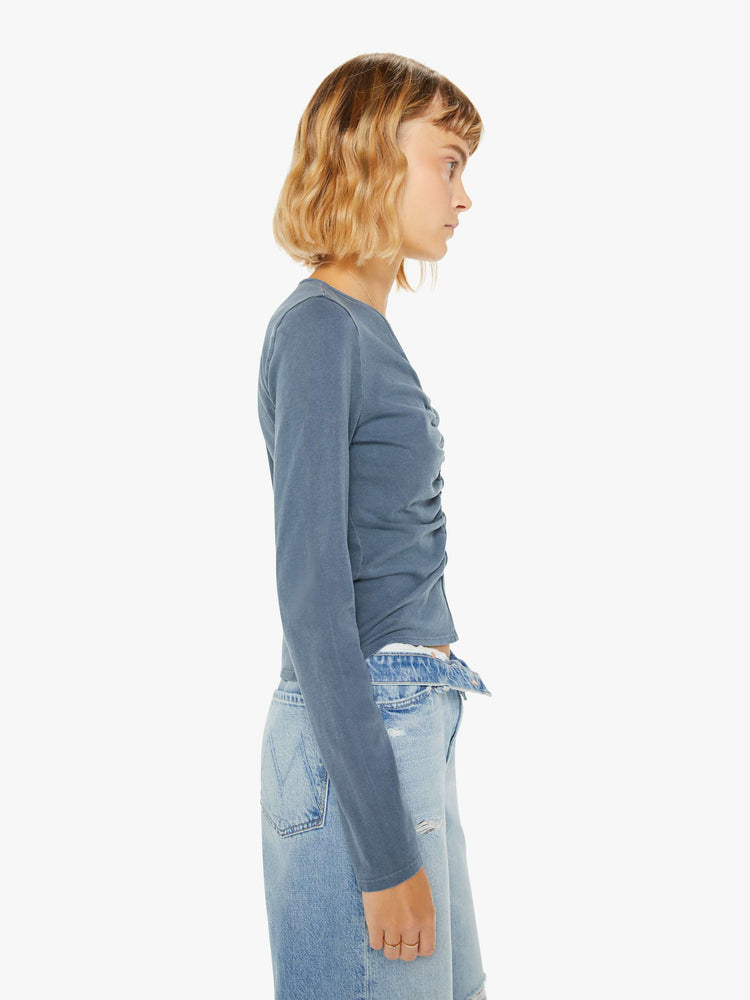 Side view of a woman navy hue long sleeve with a V-neck, gathered seam down the front and a slim fit.