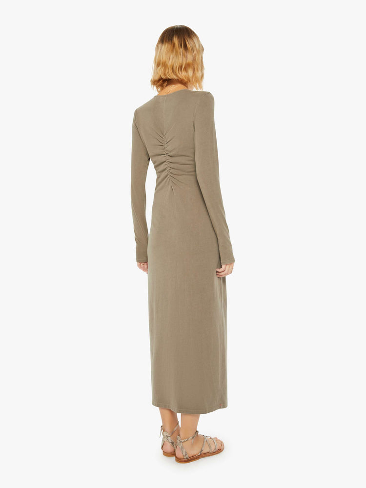 Back view of a woman dusty oluve hue long sleeve dress with a V-neck, gathered seam down the front and a slim fit.