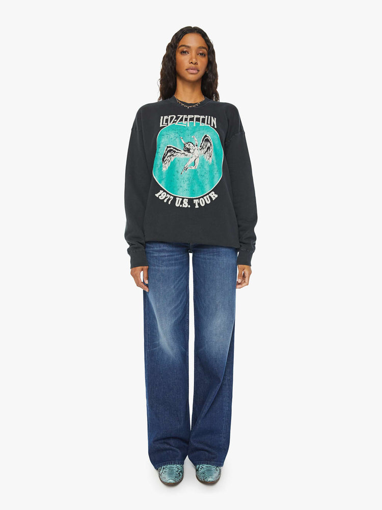 WOMEN full body view of a black sweatshirt pays homage to Led Zeppelin's 1977 tour with a faded green Icarus graphic with text in white on the front.