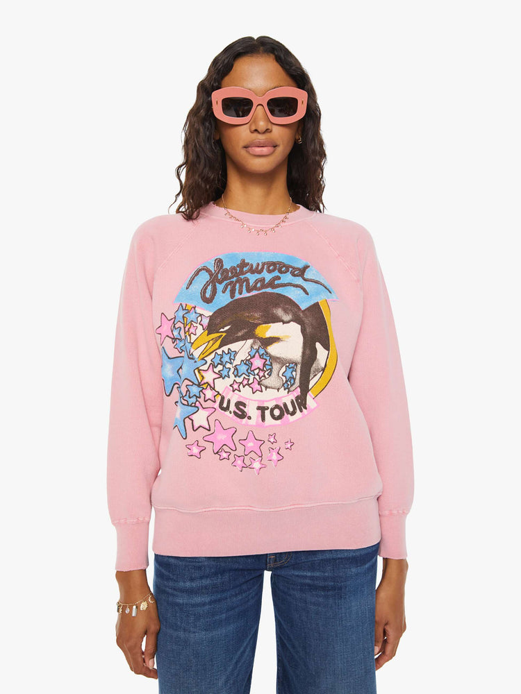 Front view of a woman pink crewneck sweatshirt  pays homage to Fleetwood Mac's U.S. tour with a colorful graphic on the front.