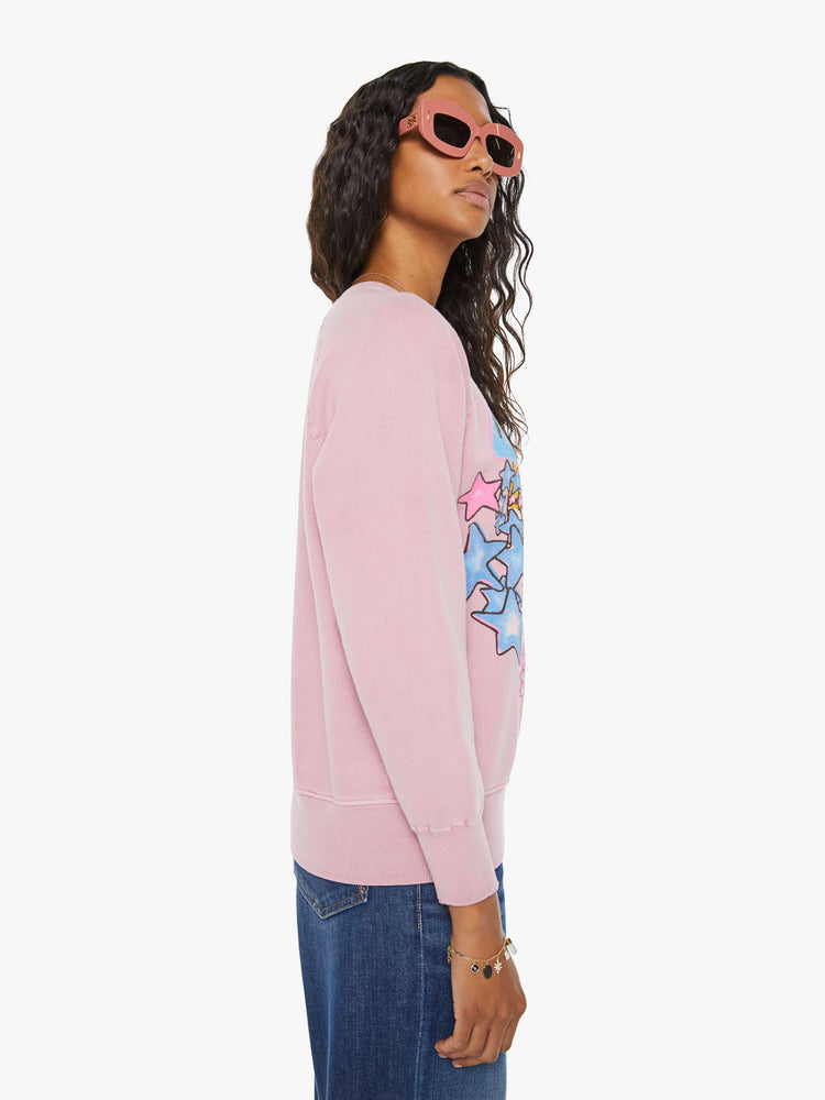 Side view of a woman pink crewneck sweatshirt pays homage to Fleetwood Mac's U.S. tour with a colorful graphic on the front.