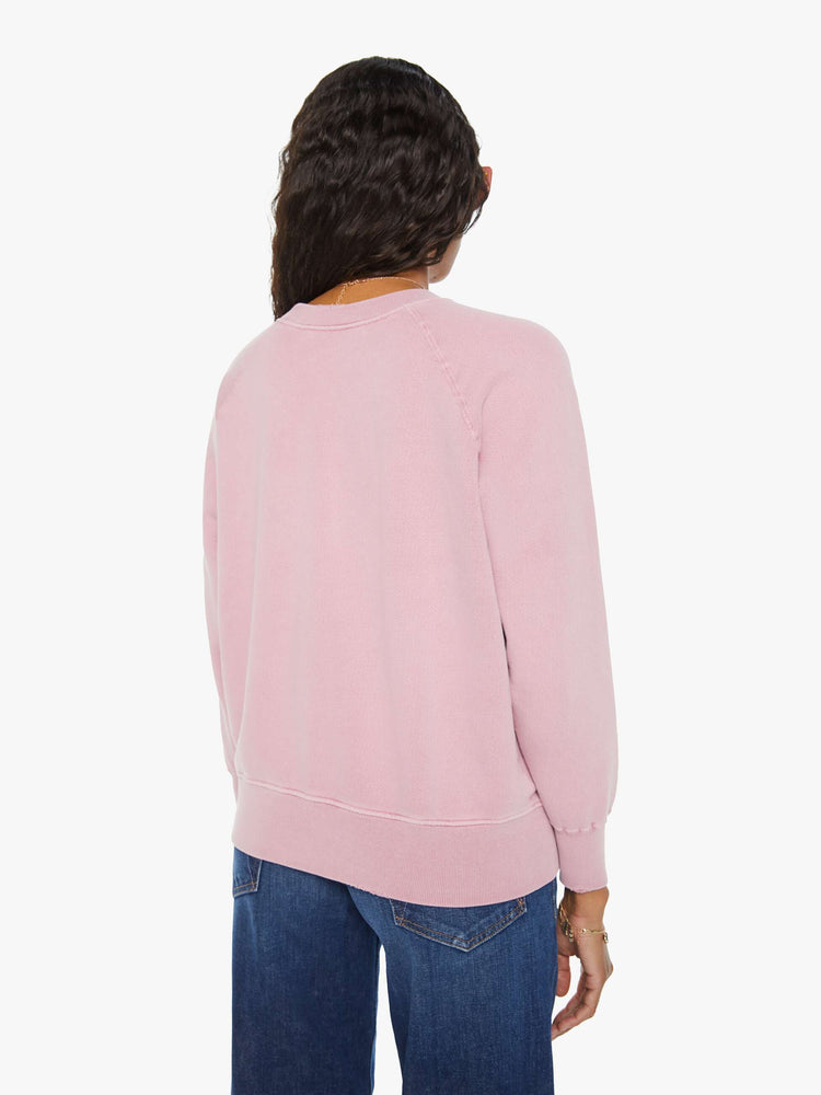 Back view of a woman pink crewneck sweatshirt pays homage to Fleetwood Mac's U.S. tour with a colorful graphic on the front.