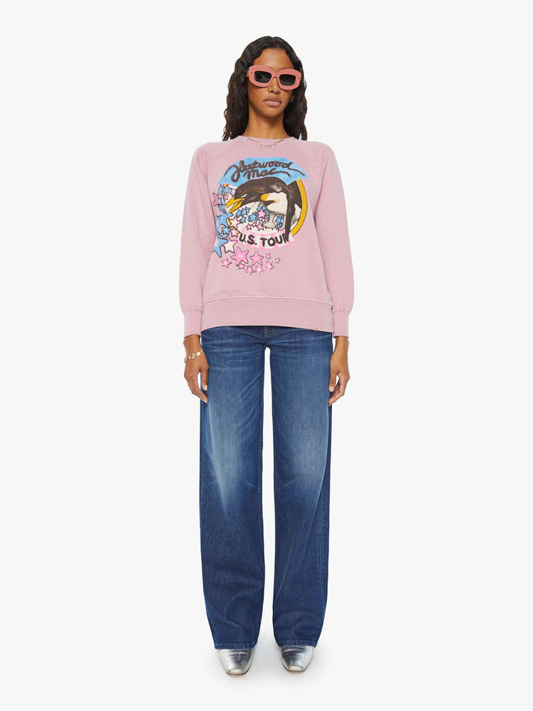 Full body view of a woman pink crewneck sweatshirt pays homage to Fleetwood Mac's U.S. tour with a colorful graphic on the front.