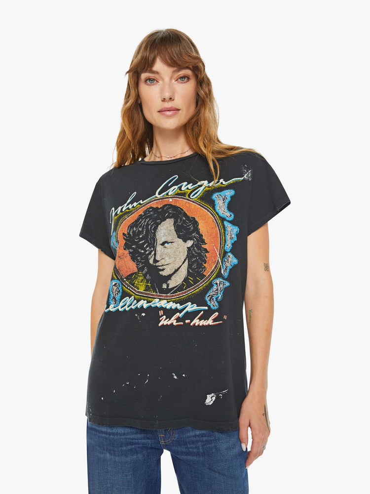 Front view of women black tee honors John Cougar Mellencamp with a faded graphic portrait on the front.