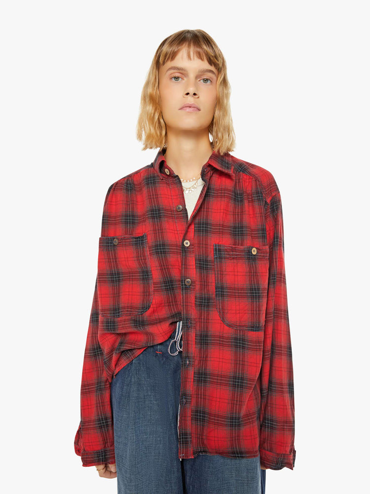 Front view of a woman red and black plaid shirt features front patch pockets, buttons down the front and a boxy, oversized fit.