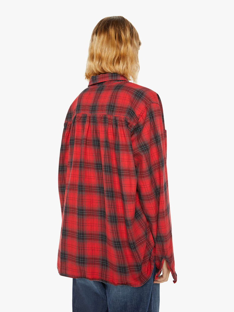 Back view of a woman red and black plaid shirt features front patch pockets, buttons down the front and a boxy, oversized fit.