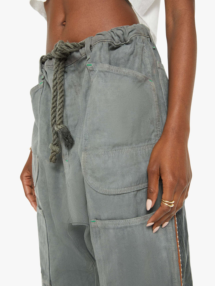 Waist view of a woman army green hue cargo pant with a mid rise, narrow straight leg and oversized patch pockets throughout.