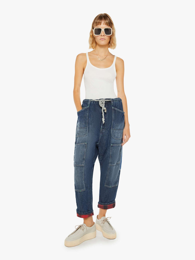 Front view of a woman sunfaded dark wash cargo pants with a mid rise, narrow straight leg and oversized patch pockets throughout.