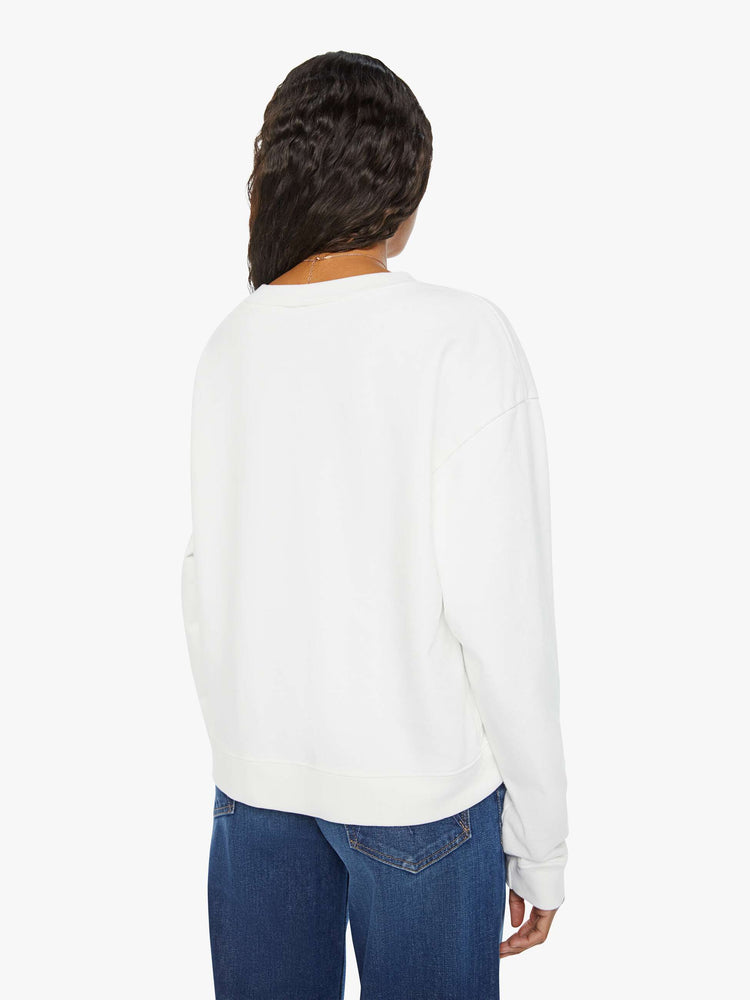 Back view of a woman white long sleeve sweatshirt features a colorful hand-drawn graphic with a variety of good luck charms.