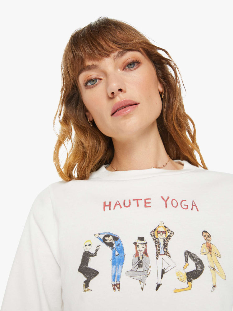 Close up view of a woman long sleeve tee with a crew neck, drop shoulders, a cropped hem and a slightly oversized fit in white and features a colorful hand-drawn text graphic that reimagines the concept of hot yoga.