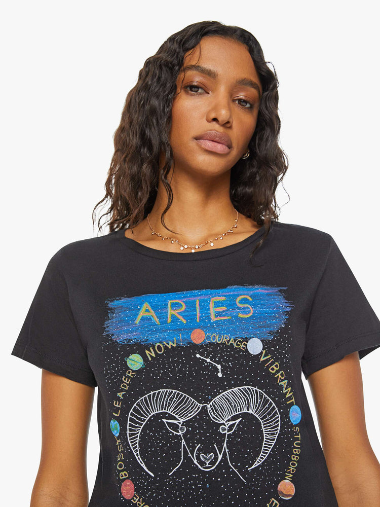 Close upview of a woman black tee features a colorful, hand-drawn graphic depicting the Aries ram.