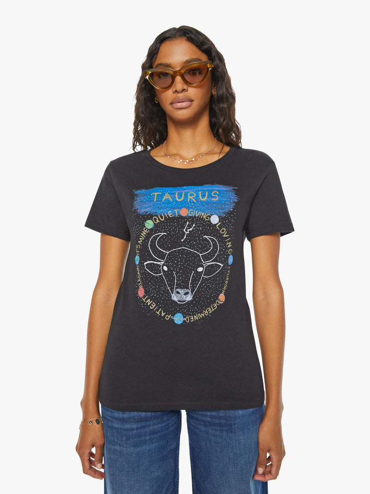 Front view of a woman black tee eatures a colorful, hand-drawn graphic depicting the Taurus bull, the earthly second astrological sign in the zodiac.