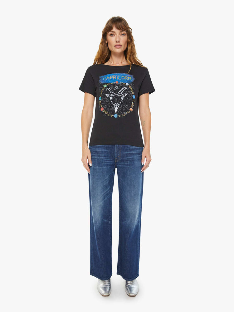 Full body view of a woman black tee features a sea-goat, the symbol of the Capricorn.