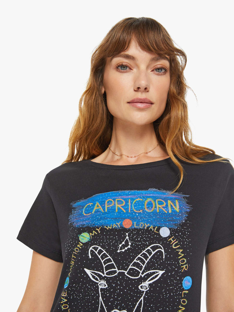 Close up view of a woman black tee features a sea-goat, the symbol of the Capricorn.