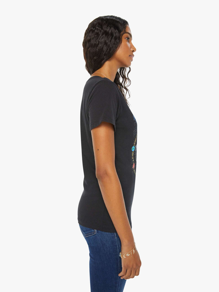 Side view of a woman black tee features the symbol of the water sign, Pisces — two fish swimming in opposite directions.