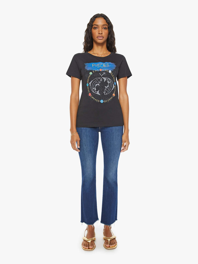 Full body view of a woman black tee features the symbol of the water sign, Pisces — two fish swimming in opposite directions.