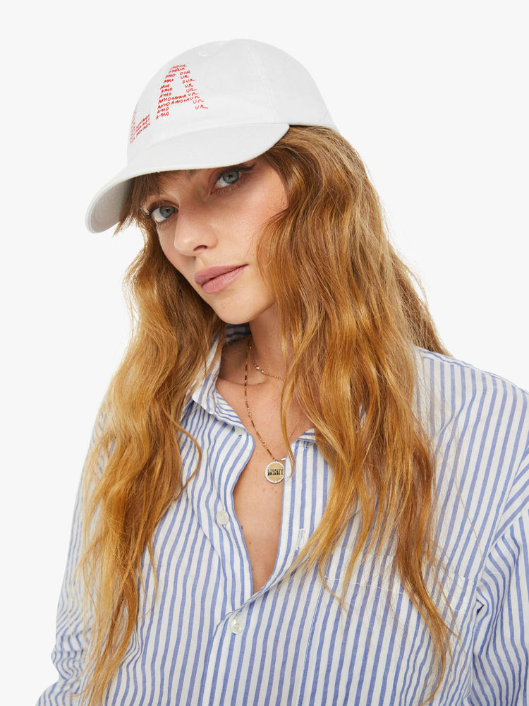 On model view of a woman white hat and is designed with a red text graphic on the front.