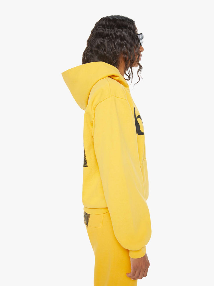 WOMEN side view of a mustard yellow patch pocket, ribbed hems and a slightly oversized sweatshirt.