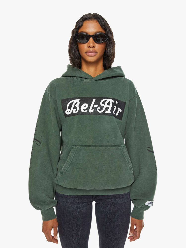 WOMEN sweatshirt in forest green has a front patch pocket, ribbed hems and a slightly oversized fit referencing the Los Angeles Neighborhood. 