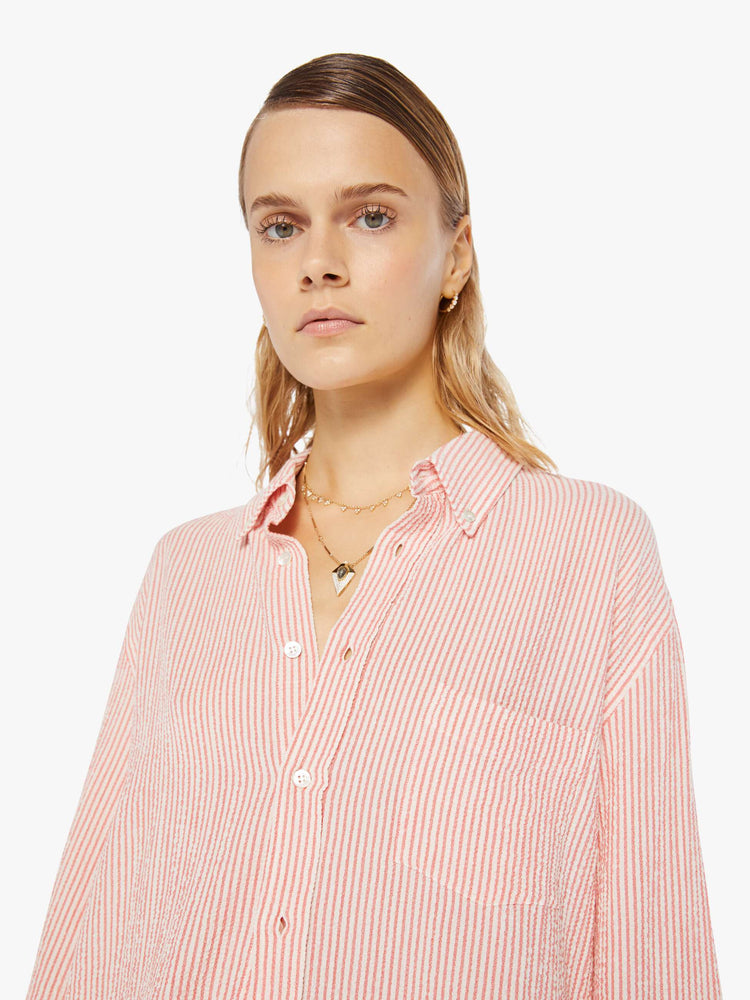 Front close up view of a womens long sleeve button down shirt featuring red and natural stripes and an oversized fit.