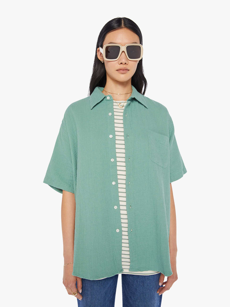 Front view of a womens green short sleeve button down shirt featuring an oversized fit.