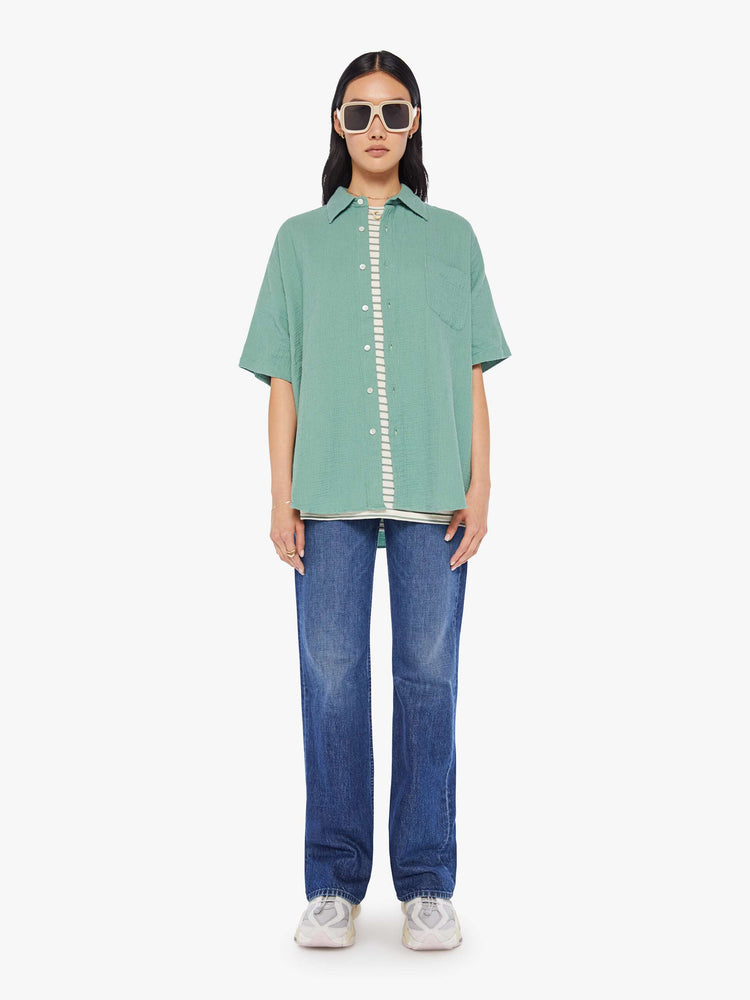 Front full body view of a womens green short sleeve button down shirt featuring an oversized fit.