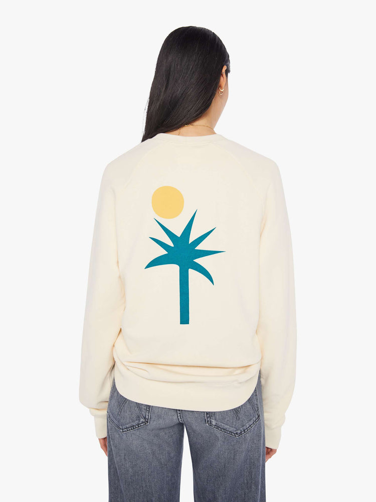 Back view of a womens ecru crew neck sweatshirt featuring an oversized fit and a large palm tree and sun graphic printed on the back.