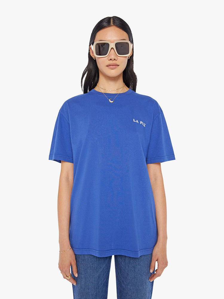 Front view of a womens blue crew neck tee featuring a logo graphic on the chest pocket.