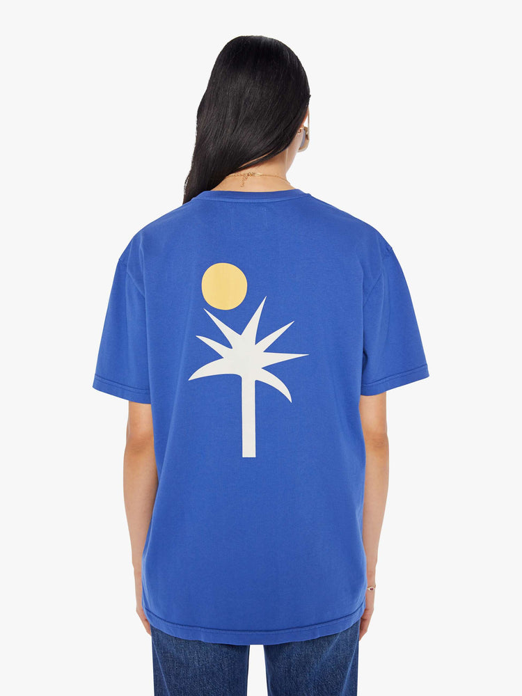 Back view of a womens blue crew neck tee featuring a large back graphic of a palm tree and sun.