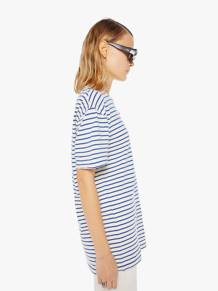 Side view of a womens white crew neck tee with blue stripes and an oversized fit.