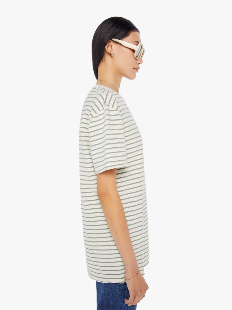 Side view of a womens white crew neck tee with green stripes and an oversized fit.