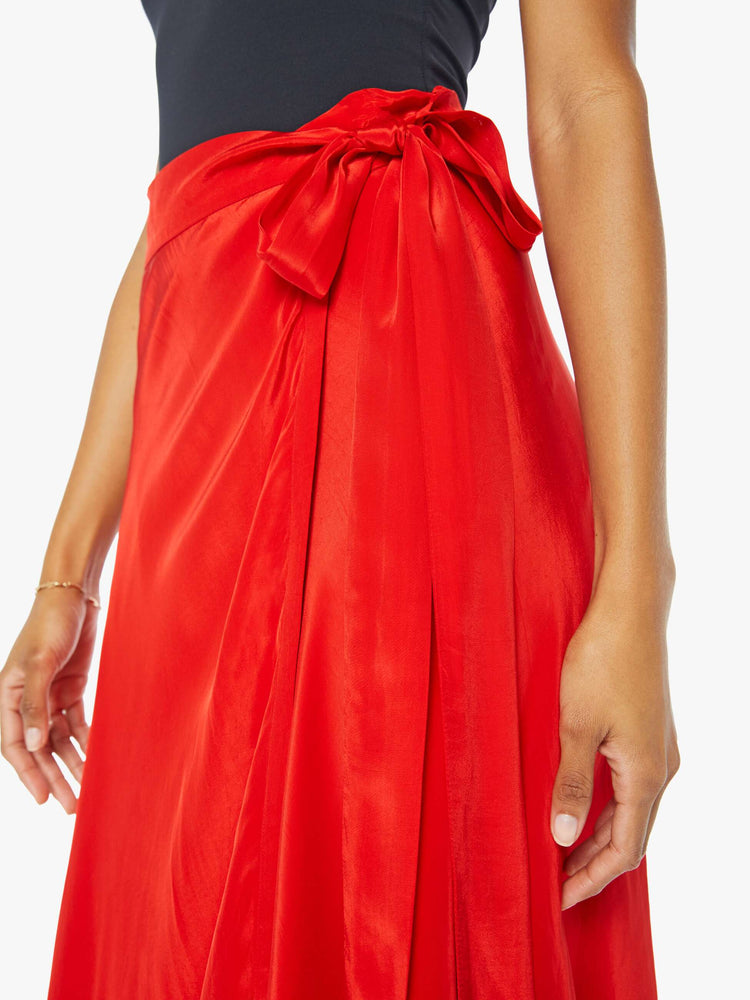 Close up view of a womens red wrap skirt featuring a high waist.