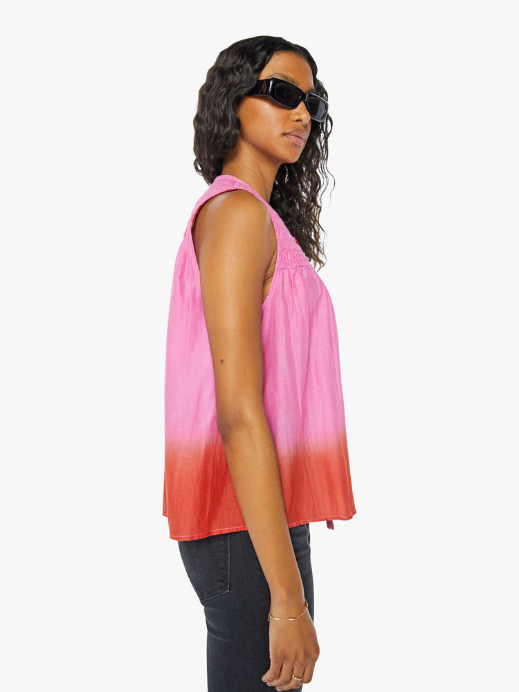 Side view of a womens sleeveless top featuring a v neck with tassels.