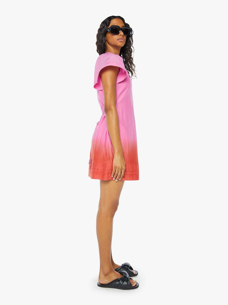 Side view of a womens short dress in a pink to red ombre, featuring short sleeves and a v neck.