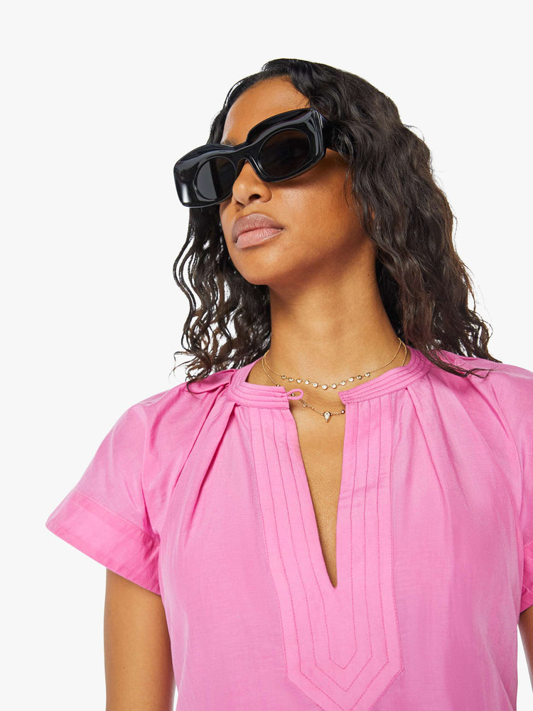 Front close up view of a womens short dress in a pink to red ombre, featuring short sleeves and a v neck.