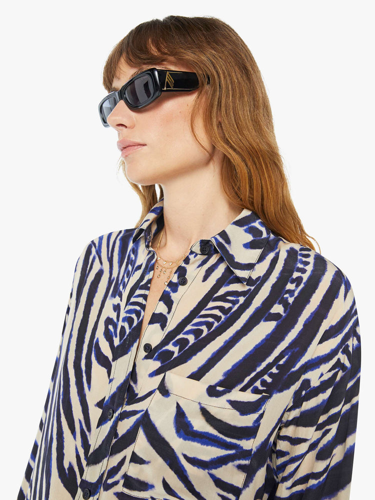 Front close up view of a womens long sleeve button down shirt featuring a zebra animal print.