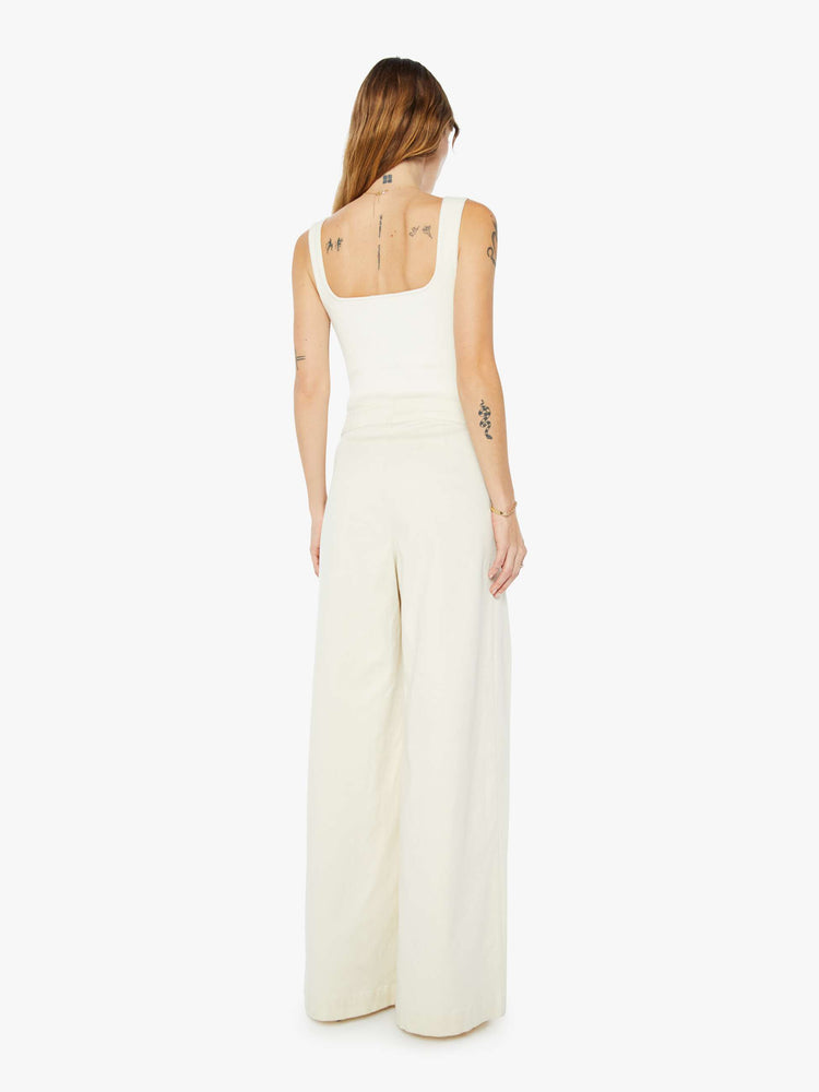 Back view of a womens off white pant featuring a high rise, a pleated wide leg, and long inseam.