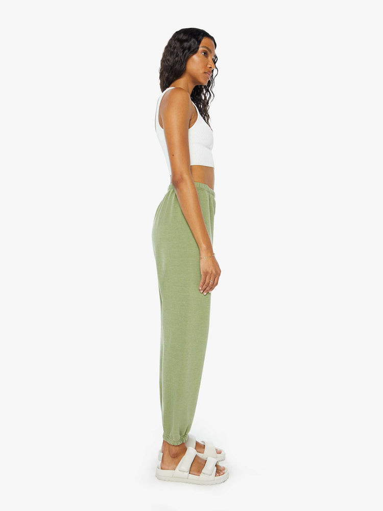 Side view of a womens green sweatpant featuring an elastic waist and a white heart printed on the hip.