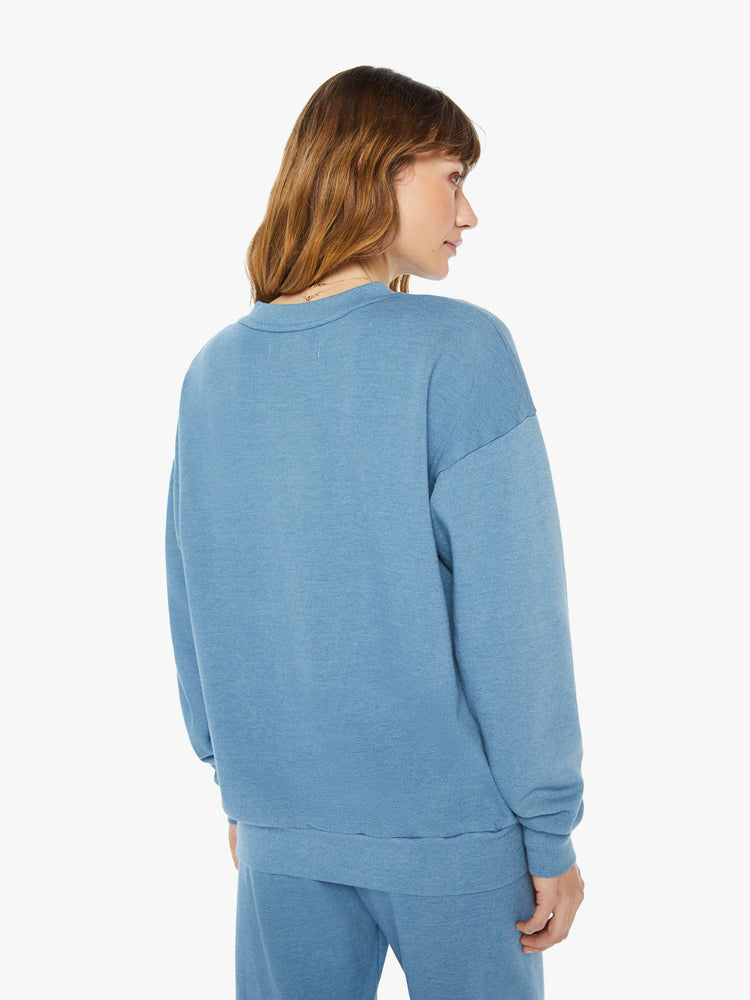 Back view of a  womens blue crew neck sweatshirt featuring a relaxed fit and SPRWMN printed on the chest.