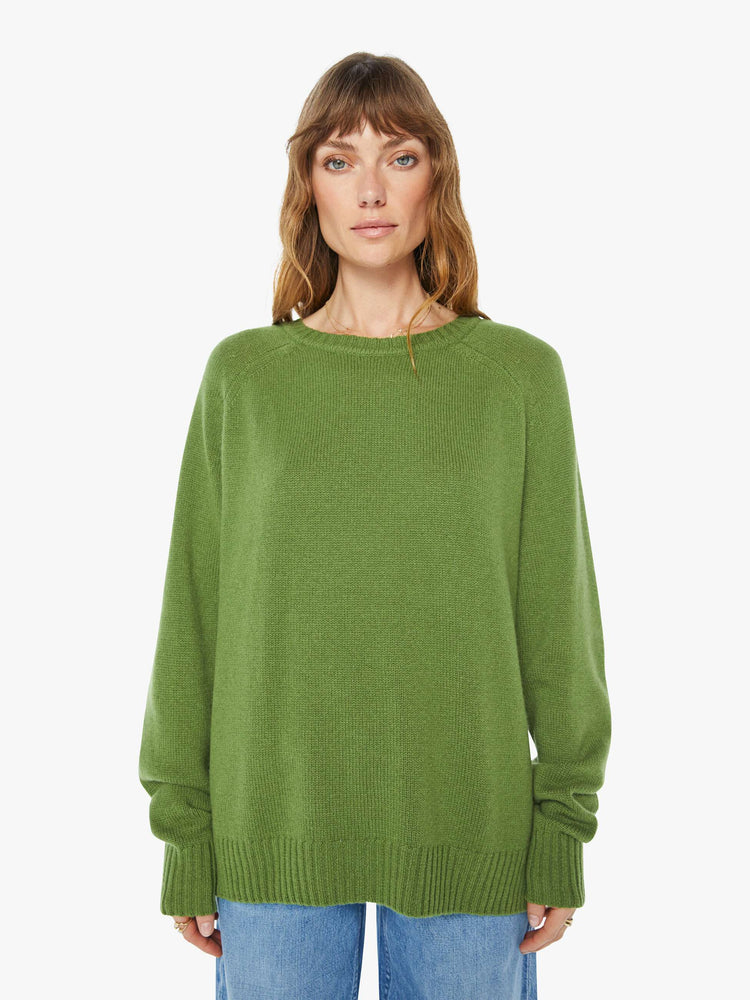 Front view of a  womens green crew neck knit sweater featuring an oversized fit.