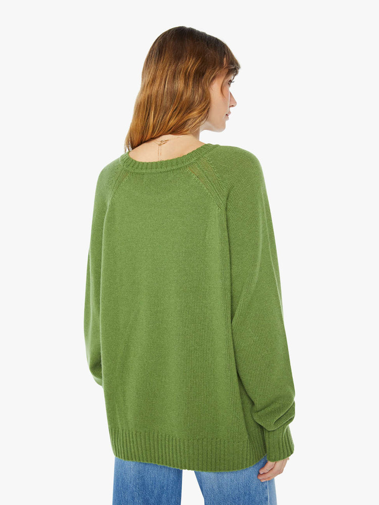 Back view of a  womens green crew neck knit sweater featuring an oversized fit.