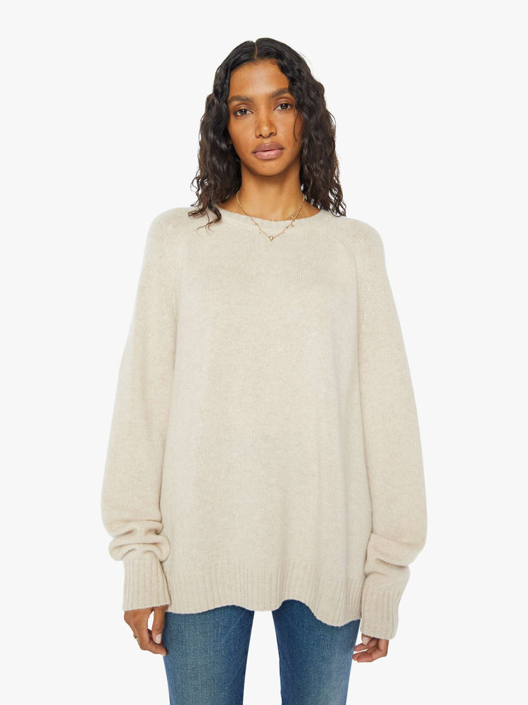 Front view of a  womens beige crew neck knit sweater featuring an oversized fit.