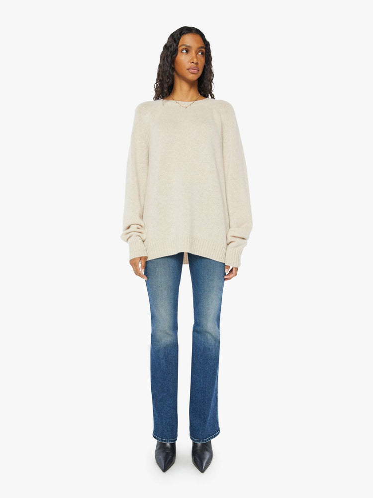 Front full body view of a  womens beige crew neck knit sweater featuring an oversized fit.
