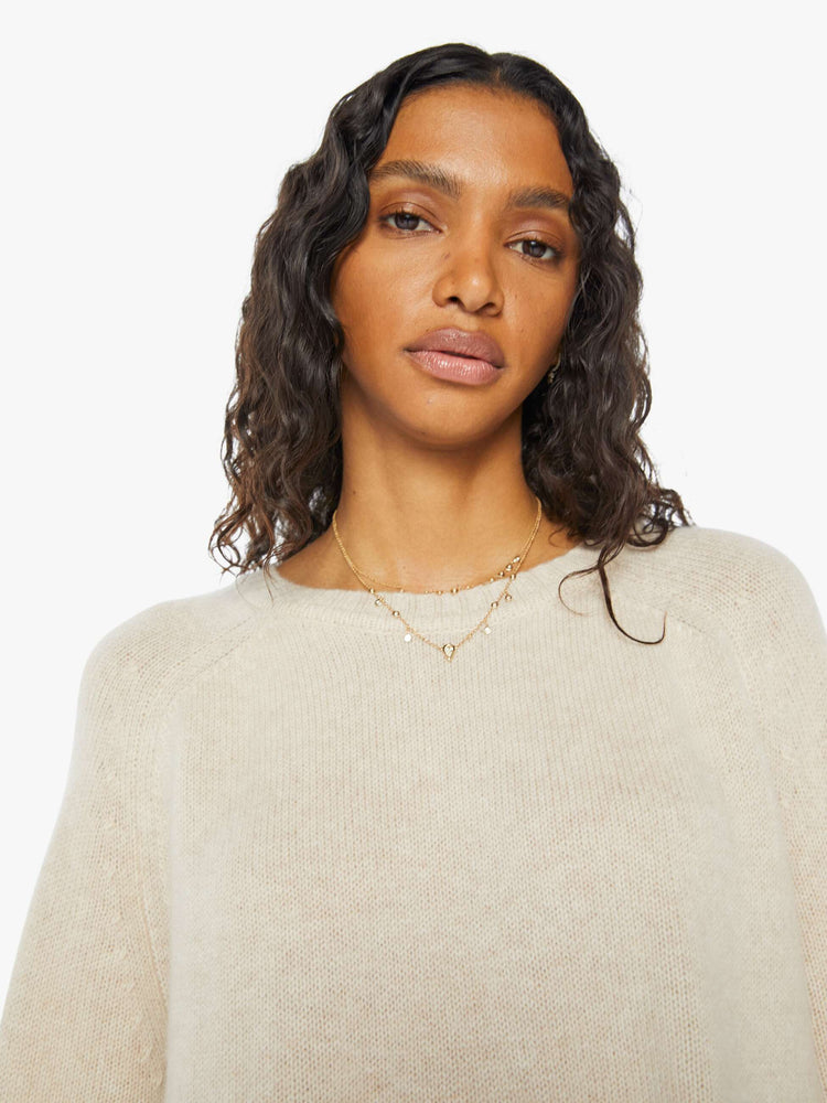 Front close up view of a  womens beige crew neck knit sweater featuring an oversized fit.