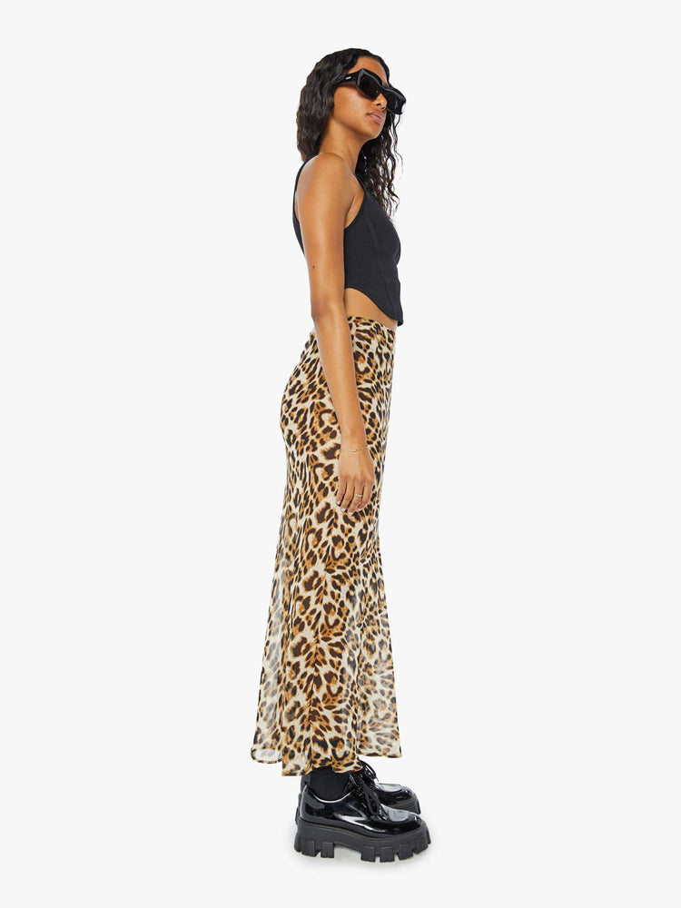 Side view of a womens sheer maxi skirt featuring a leopard print and high rise.