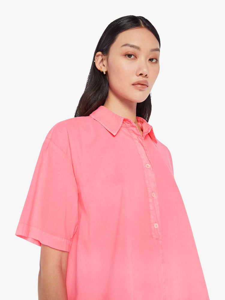 Front close up view of a womens neon pink collar shirt featuring a 3/4 length button, dropped short sleeves, and a cropped boxy fit.