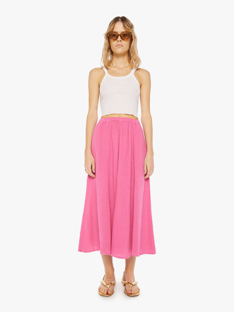 Front view of a woman wearing a pink, calf-length skirt with elastic waistband